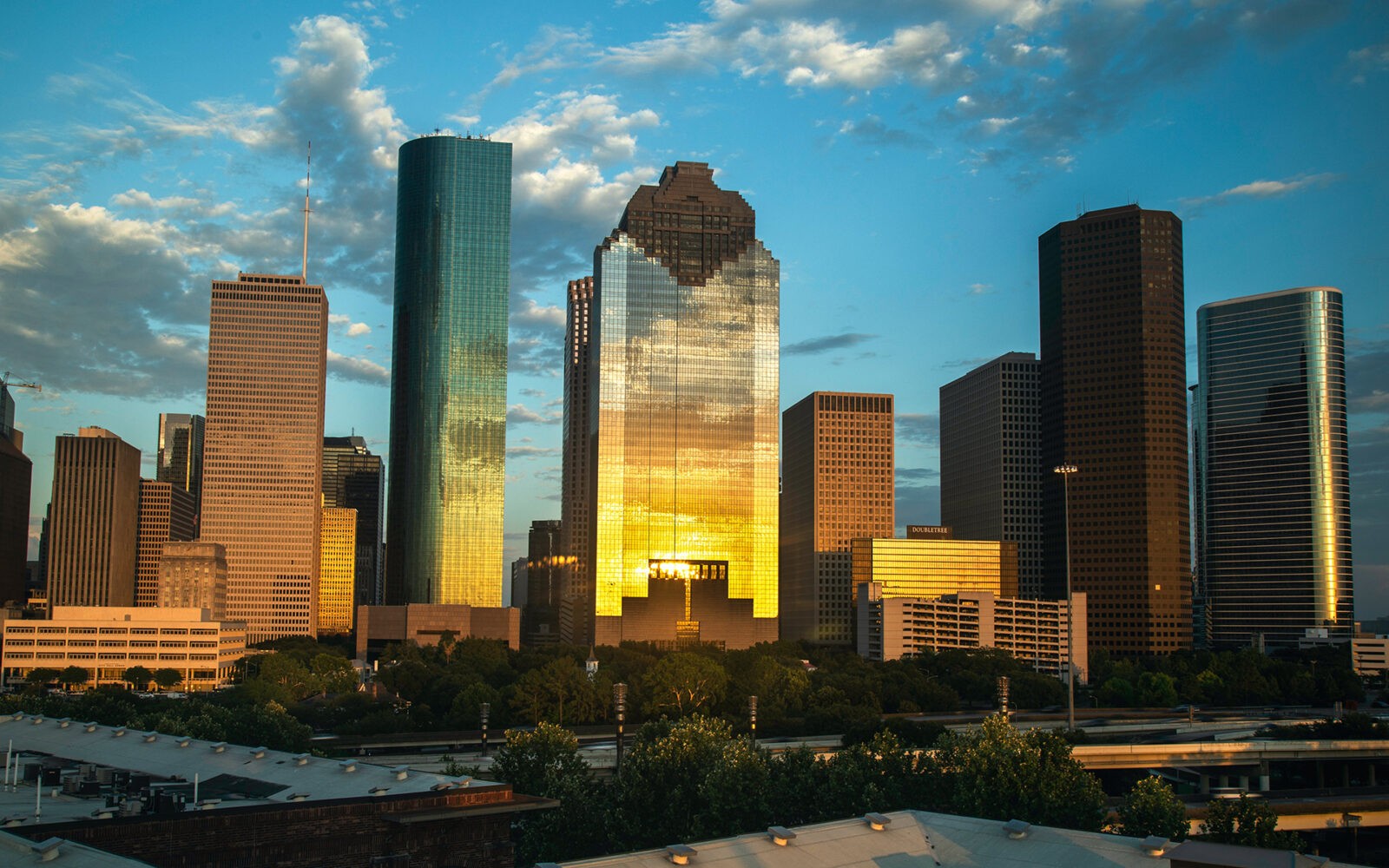 CloudMasonry - Texas Based Salesforce Consulting - Houston Office Landing Page Image - Houston skyline at sunset with golden reflections.